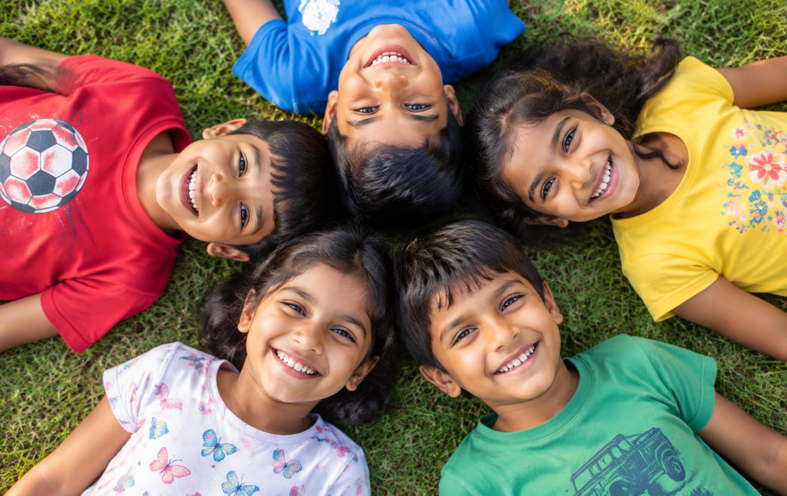 Students of Brighton International School lying in a circle on the campus lawn